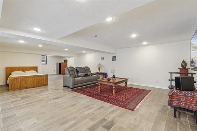 living area with recessed lighting, baseboards, visible vents, and light wood finished floors