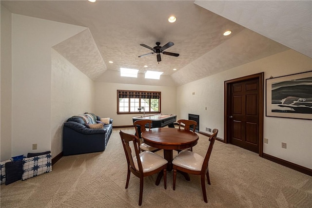 dining space with light carpet, ceiling fan, baseboards, and vaulted ceiling