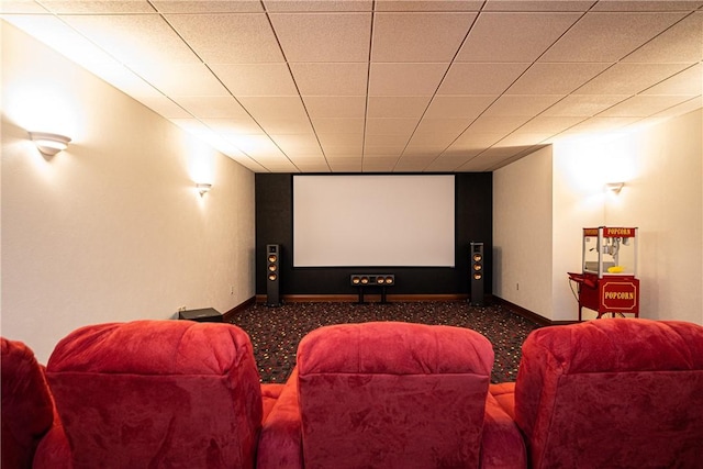 cinema featuring a paneled ceiling and baseboards