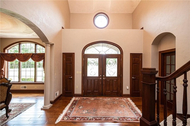 entryway featuring hardwood / wood-style flooring, baseboards, visible vents, and arched walkways