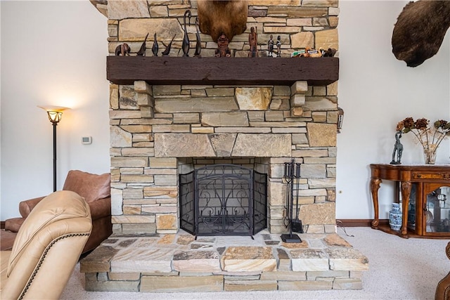 room details featuring baseboards and a stone fireplace