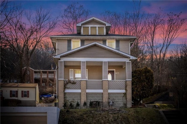 traditional style home featuring covered porch and brick siding