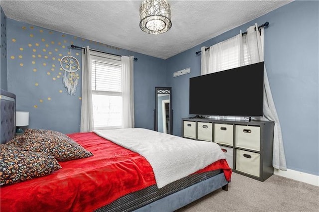 bedroom with carpet, a textured ceiling, and baseboards