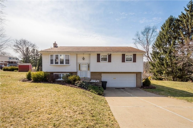 split foyer home featuring a garage, driveway, a chimney, and a front lawn