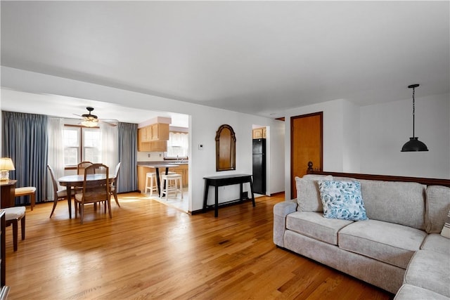 living room featuring light wood-style floors and a ceiling fan