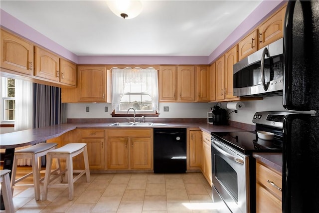 kitchen featuring light tile patterned floors, stainless steel appliances, and a sink