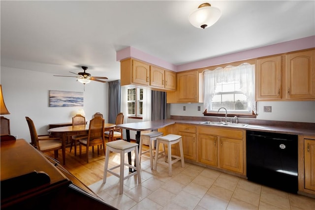 kitchen with a ceiling fan, black dishwasher, light brown cabinets, and a sink