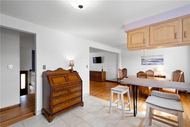 dining space featuring light wood-style floors and baseboards