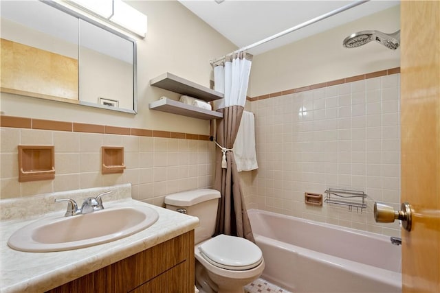 full bath with toilet, shower / tub combo, vanity, tile walls, and wainscoting