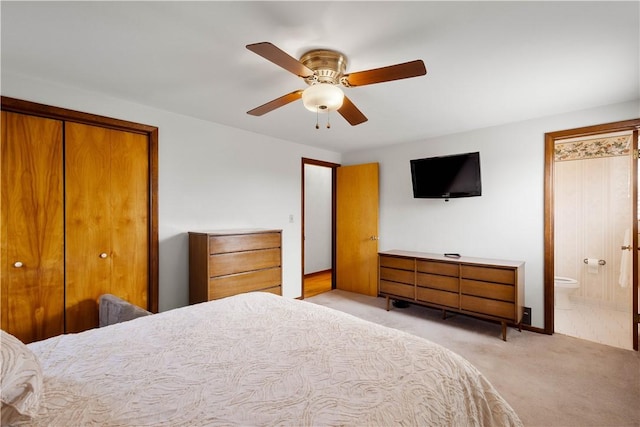 bedroom featuring light carpet, a closet, a ceiling fan, and ensuite bathroom