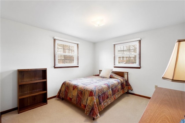 bedroom featuring baseboards and light colored carpet