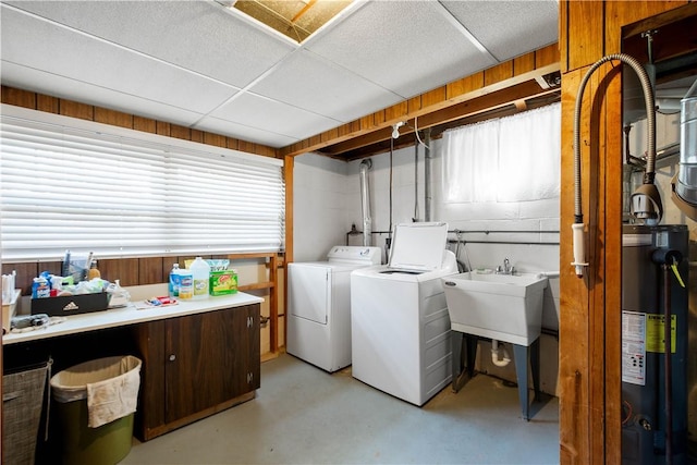 laundry area with a healthy amount of sunlight, water heater, a sink, and washer and clothes dryer