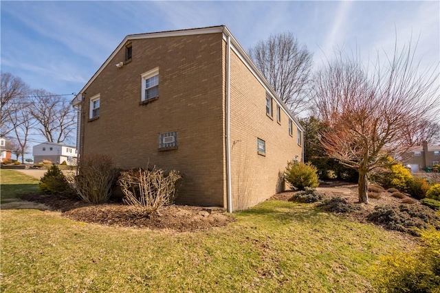 view of property exterior featuring a lawn and brick siding