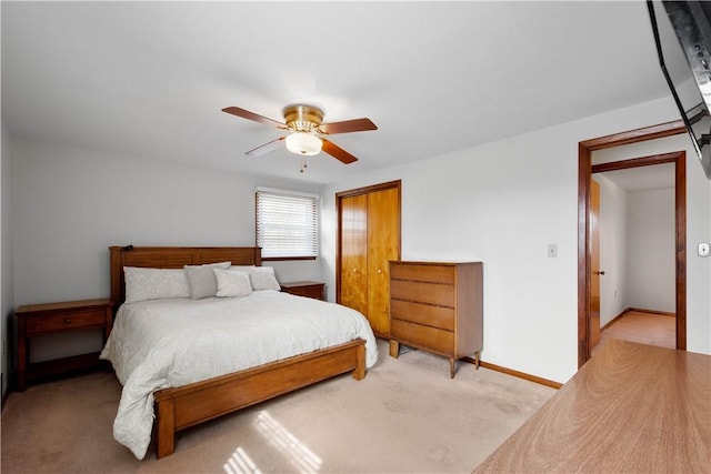 bedroom featuring baseboards, a closet, a ceiling fan, and light colored carpet