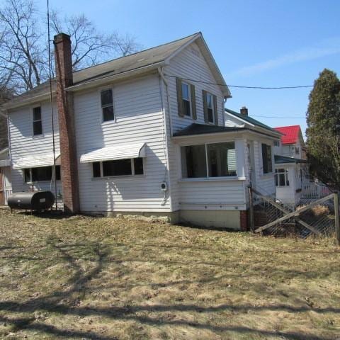 view of side of home with a chimney and heating fuel