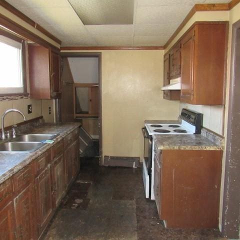 kitchen featuring electric range oven, brown cabinets, a sink, and under cabinet range hood