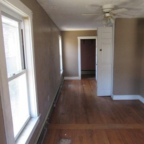 hall with baseboards and wood finished floors