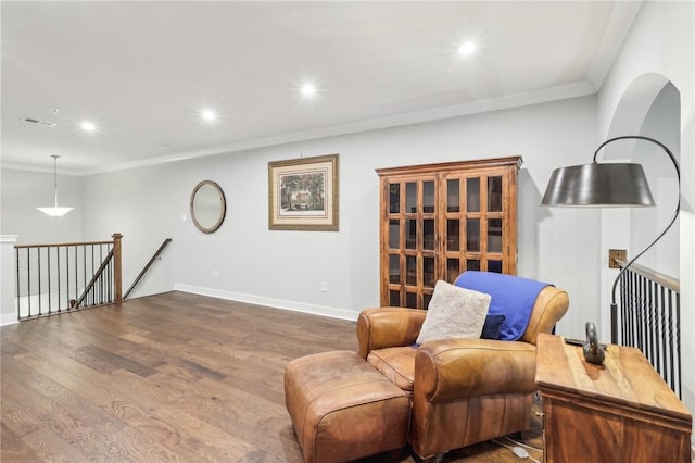 living area with baseboards, dark wood finished floors, ornamental molding, an upstairs landing, and recessed lighting