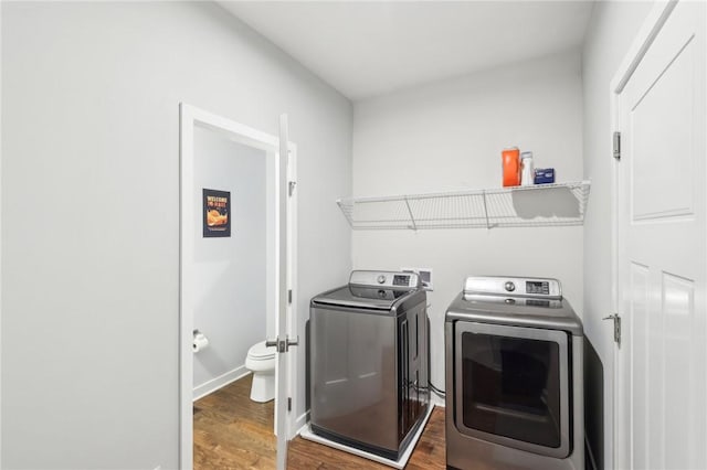 laundry area featuring washer and dryer, laundry area, baseboards, and wood finished floors