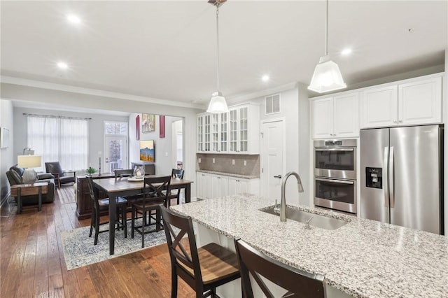 kitchen featuring visible vents, decorative backsplash, appliances with stainless steel finishes, dark wood-style flooring, and a sink