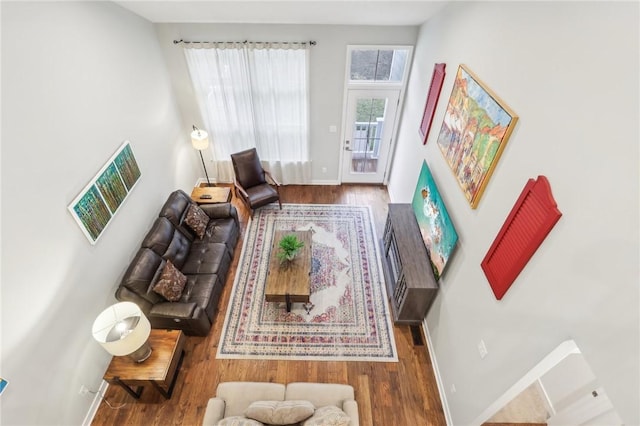 living area with baseboards and wood finished floors