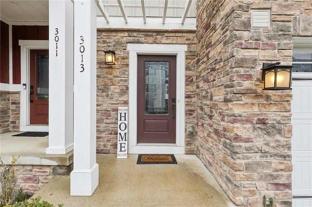 entrance to property featuring stone siding and brick siding