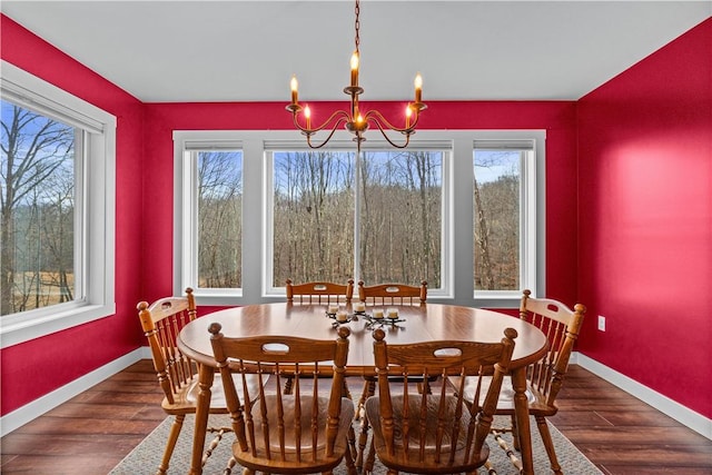 dining space with a healthy amount of sunlight, a notable chandelier, baseboards, and wood finished floors