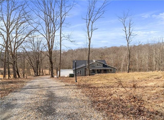 exterior space with driveway and a forest view