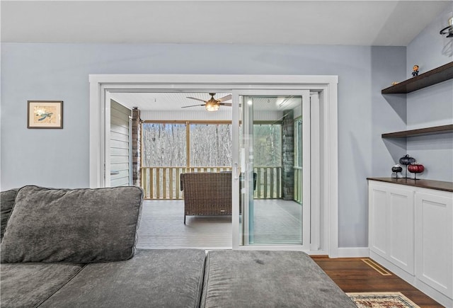 doorway to outside with dark wood-type flooring, baseboards, and a ceiling fan