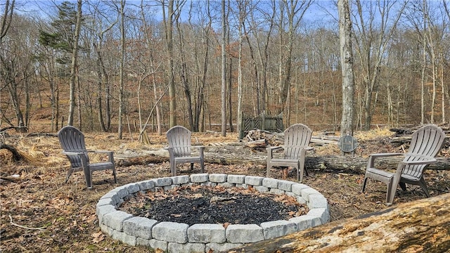 view of patio featuring a forest view and an outdoor fire pit