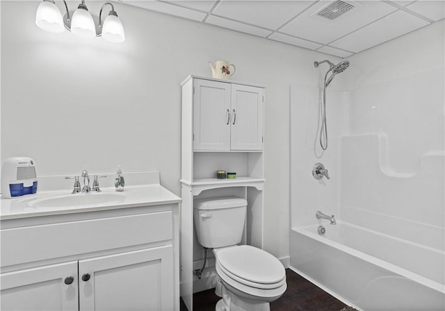 bathroom with shower / bathtub combination, visible vents, toilet, vanity, and a drop ceiling