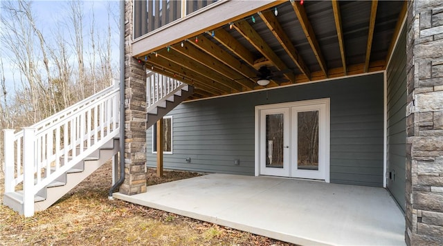 view of patio featuring a ceiling fan, french doors, and stairway