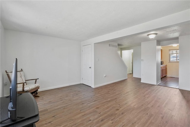 exercise area featuring baseboards, visible vents, and wood finished floors