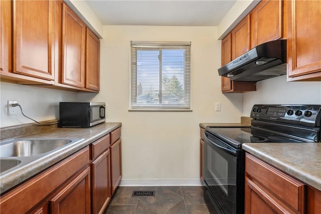 kitchen featuring visible vents, baseboards, brown cabinetry, black electric range oven, and under cabinet range hood