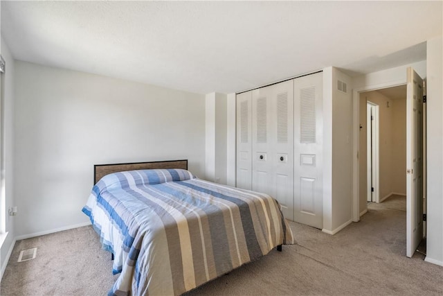 bedroom featuring a closet, carpet flooring, visible vents, and baseboards