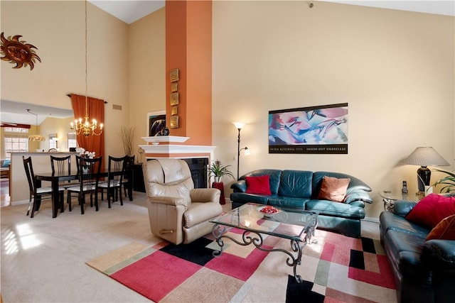 living area with carpet floors, a fireplace, a high ceiling, and an inviting chandelier