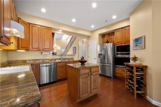 kitchen featuring dark wood-type flooring, a center island, stainless steel appliances, and a sink