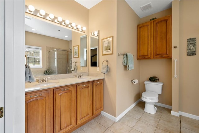 bathroom with a stall shower, baseboards, toilet, tile patterned flooring, and a sink