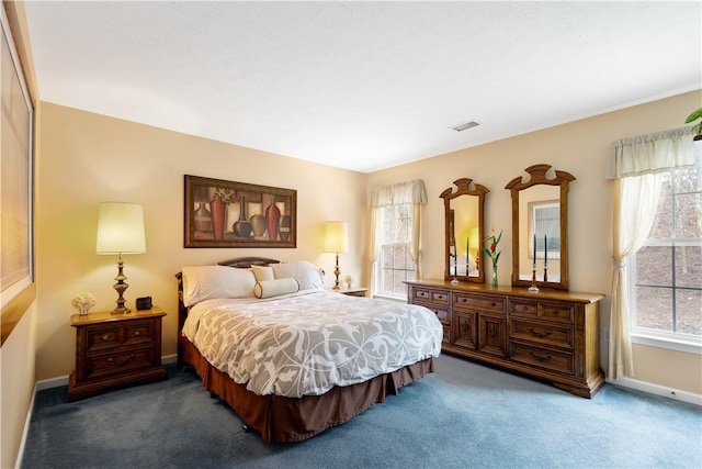 carpeted bedroom featuring baseboards and visible vents