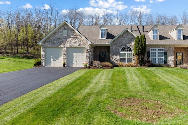 view of front of house featuring a garage, stone siding, a front lawn, and aphalt driveway