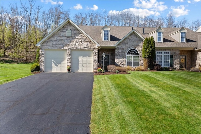 view of front of house featuring stone siding, a front lawn, and aphalt driveway