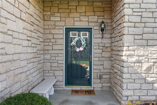 property entrance featuring stone siding and brick siding