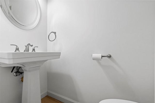 half bathroom with toilet and baseboards