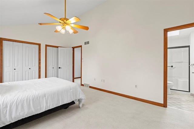 bedroom with connected bathroom, light carpet, visible vents, multiple closets, and baseboards