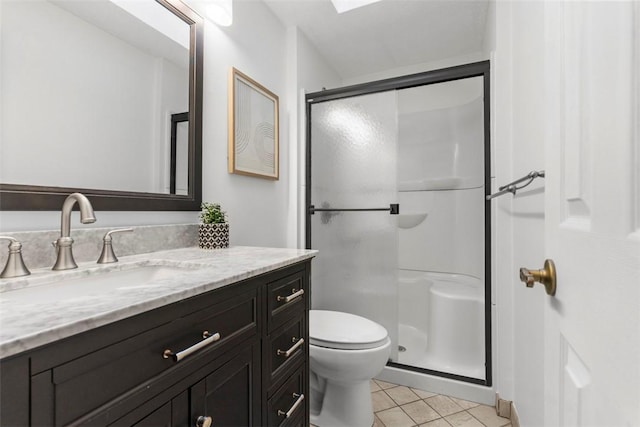 bathroom with a stall shower, vanity, toilet, and tile patterned floors