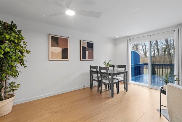 dining room with light wood-type flooring, ceiling fan, and baseboards