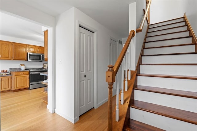 staircase with wood finished floors and baseboards