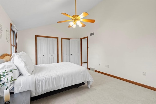 bedroom with multiple closets, visible vents, light carpet, and baseboards