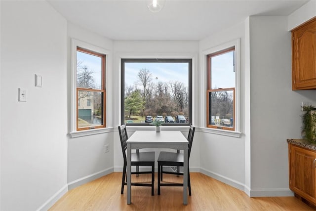 dining space with light wood-style floors and baseboards