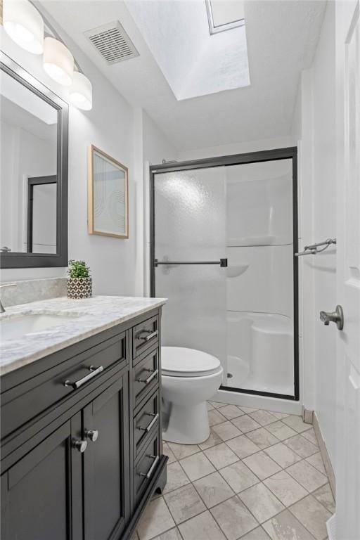 full bathroom featuring visible vents, toilet, a shower stall, vanity, and tile patterned floors